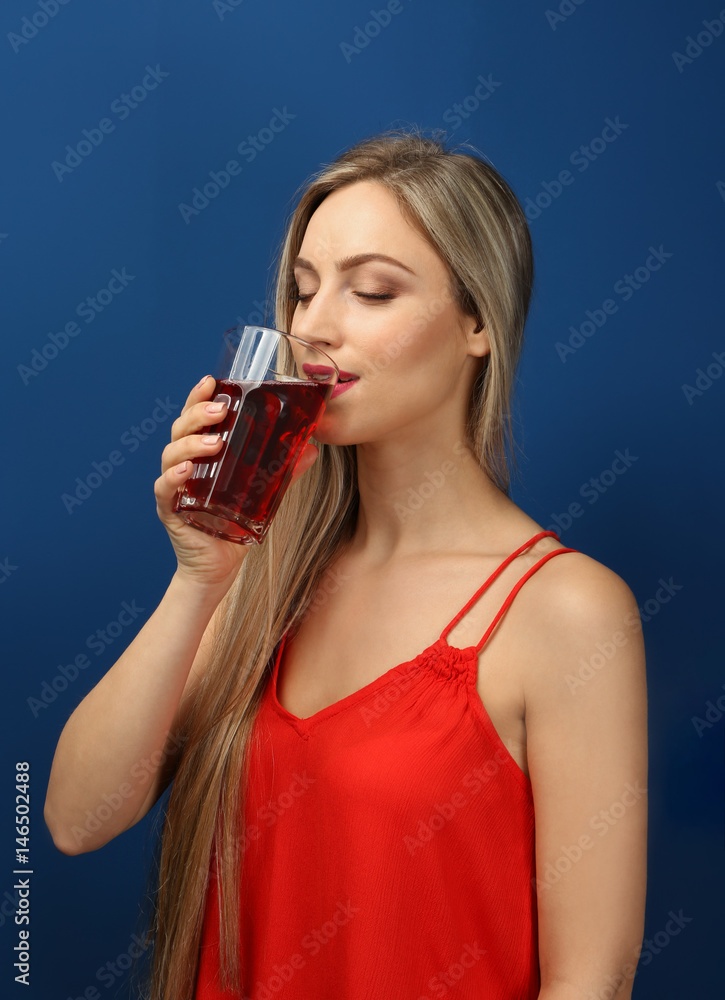 Beautiful young woman drinking fresh juice on color background Beautiful young woman drinking fresh juice on color background