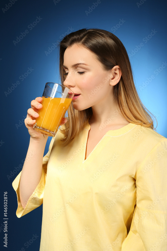 Beautiful woman drinking fresh juice on color background Beautiful woman drinking fresh juice on color background