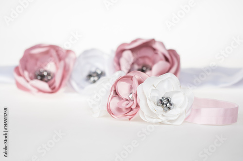 Elastic headband with flowers for a baby girl, with a matching head-band for the mother in background, cute fashion accessories for weddings © RedHanded