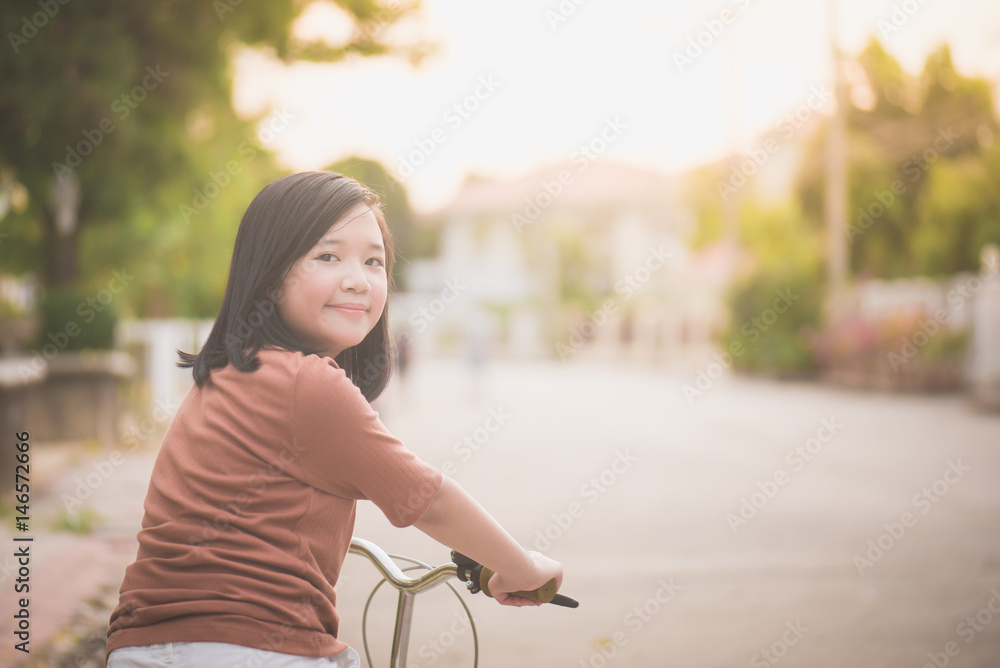 Asian girl riding bicycle in the sunlight Asian girl riding bicycle in the sunlight