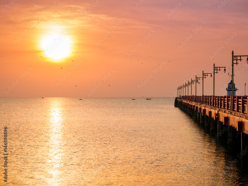 Sunrise over the sea with bridge and lighthouse