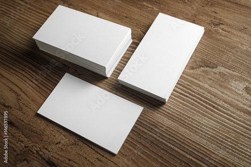 Photo of blank business cards on a wooden table background. Template for ID. 