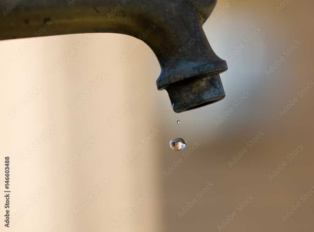 A drop of water close up. Old copper tap. A drop of water close up. Old copper tap.