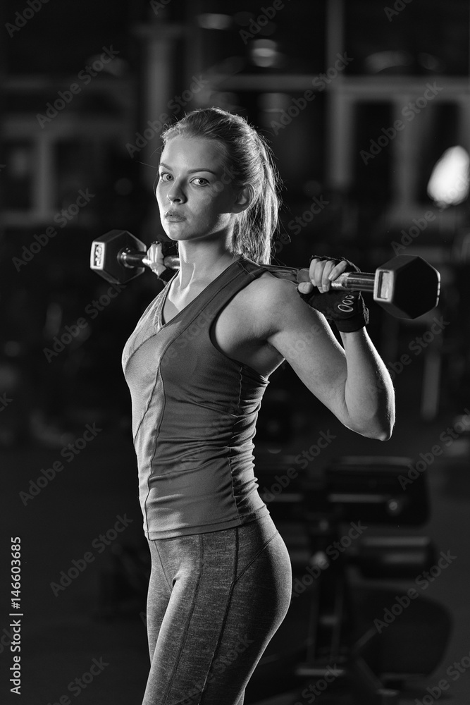 Beautiful sporty woman doing power fitness exercise at sport gym. Girl with  dumbbell. Black and white. Stock Photo | Adobe Stock