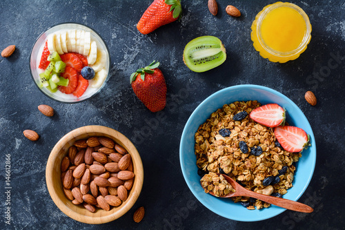 Granola, fresh fruits, berries, nuts and honey. Healthy breakfast foods