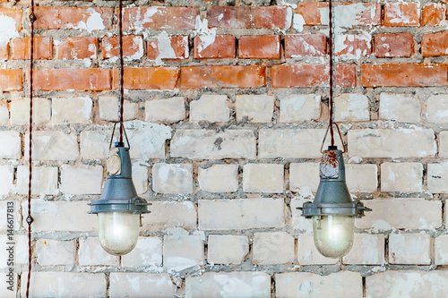 Hanging vintage lamps in a loft style on the brick wall background.