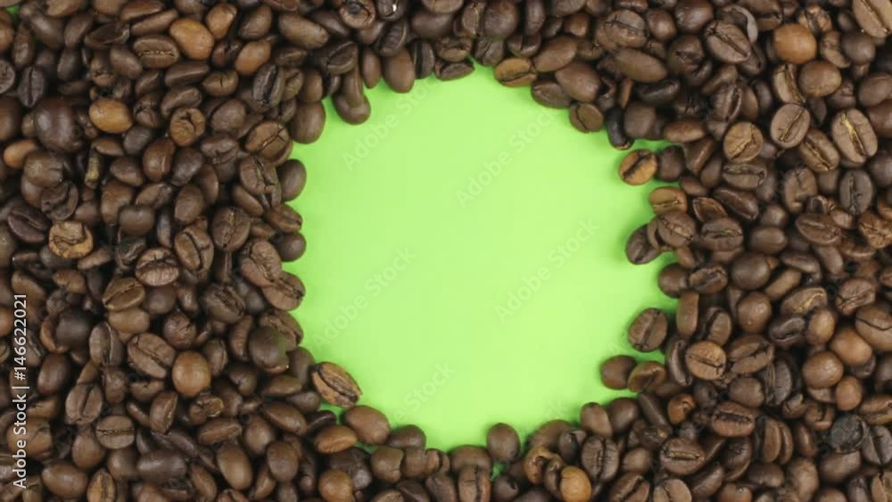 Rotation of the coffee beans lying on a green screen, chroma key. Rotation of the coffee beans lying on a green screen, chroma key.