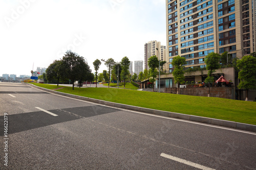 Empty road surface floor with City streetscape buildings © Aania