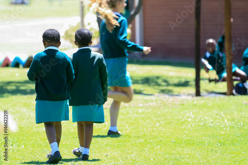 two girls on playground with kids in background
