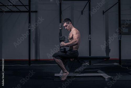 one young man, bodybuilder sitting, flat bench, dumbbell