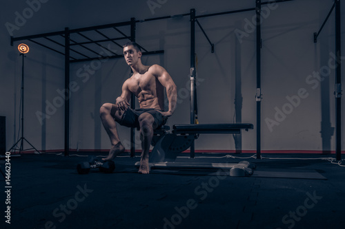 one young man, low angle view, bodybuilder muscular sitting posing
