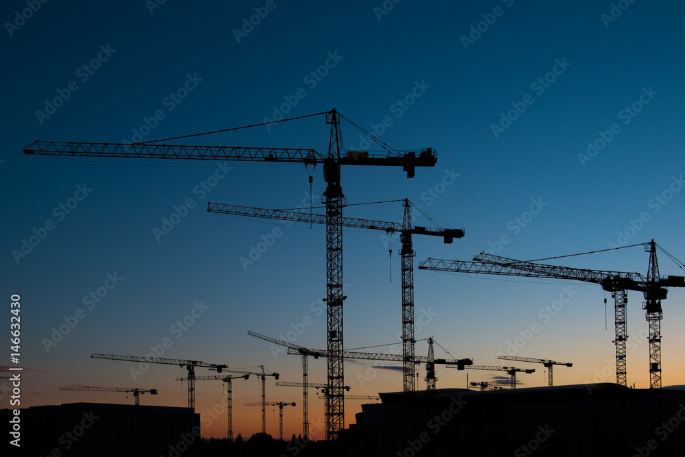 construction cranes on sunset sky 