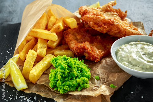 Quadro em tela British Traditional Fish and chips with mashed peas, tartar sauce on crumpled paper