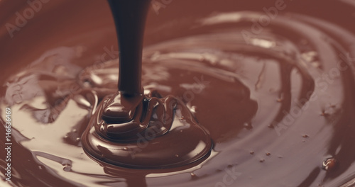 premium dark melted chocolate being poured from spoon closeup toned, 4k photo