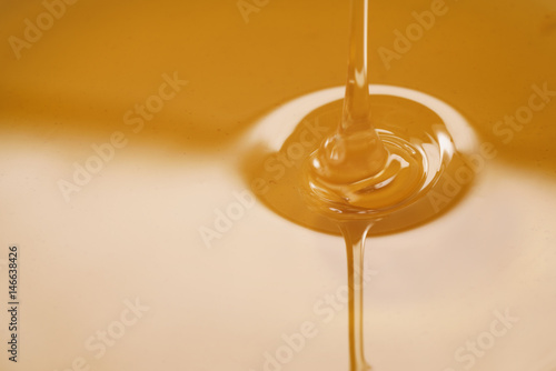 closeup of pouring organic honey, amber golden color