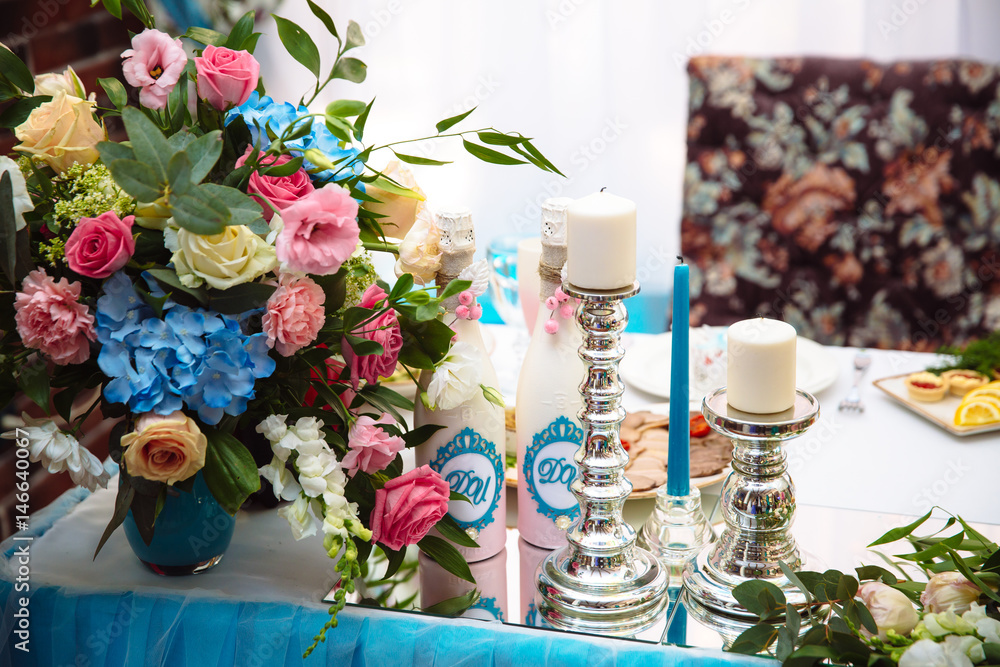 Wedding decorated table with candles and champagne in the tenderly light blue style
