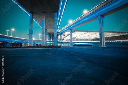 Empty road floor with city viaduct bridge of neon lights night © Aania