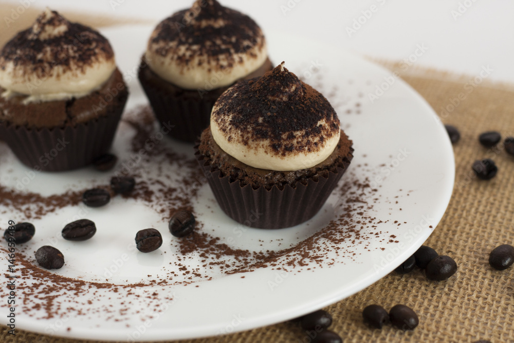 Tiramisu Cupcakes on white round plate, missing one Tiramisu Cupcakes on white round plate, missing one