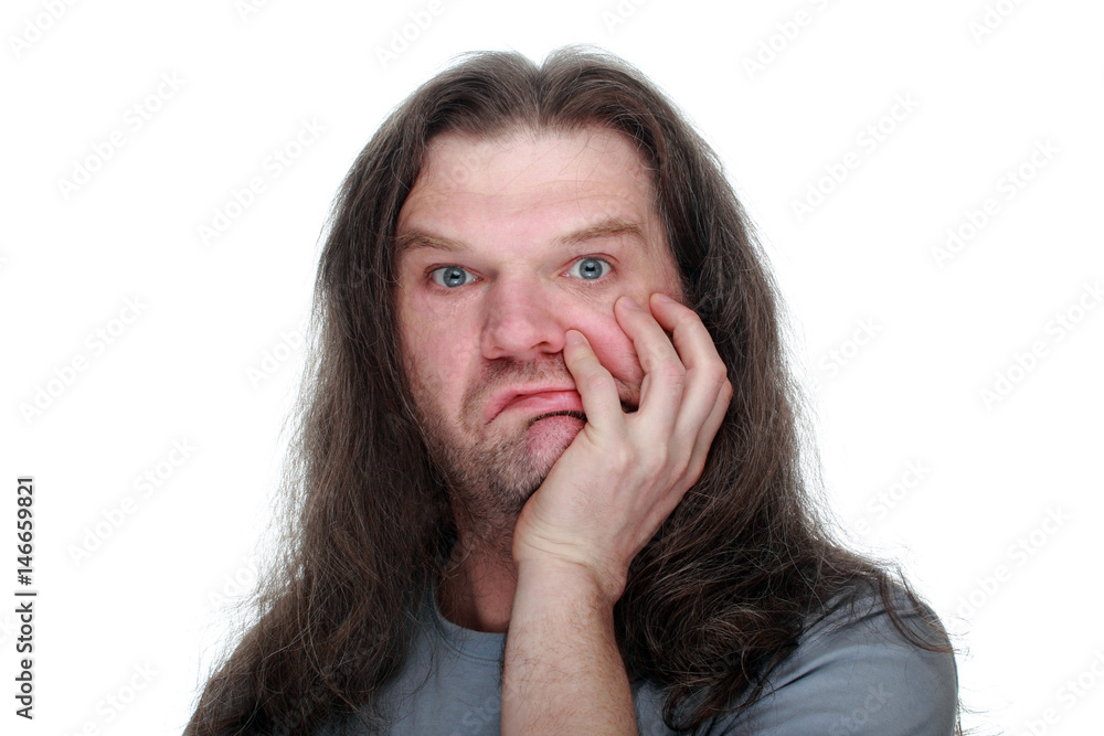 Adult man with long hair looks at the camera in surprise, making a face. Adult man with long hair looks at the camera in surprise, making a face.