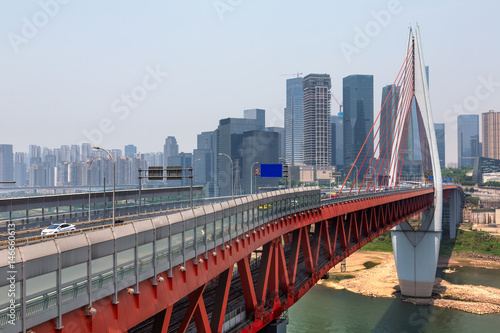 Long bridge across river with cityscape in background.