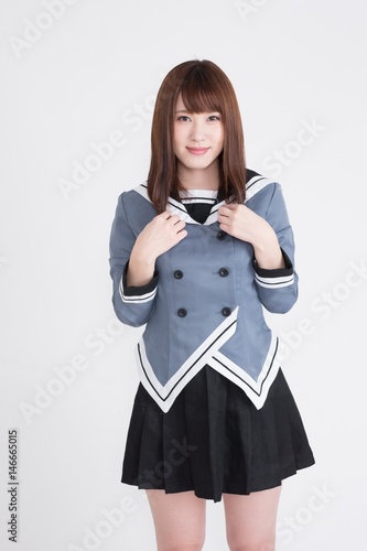 若い女性が制服を着ています。手の表情が豊かです。サイネージや広告宣伝に適した画像です。この画像の背景は、白です。