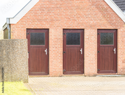 Drei braune Türen eines Hauses © GM Photography