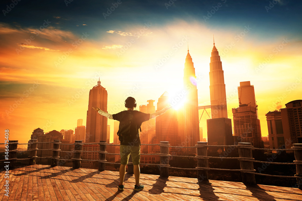 Fototapeta premium Silhouette man raise hands up for him success, beautiful cityscapes skyline view. morning sunrise scene .