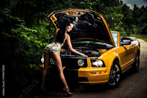 девушка заглядывает под капот автомобиля © lufotolab