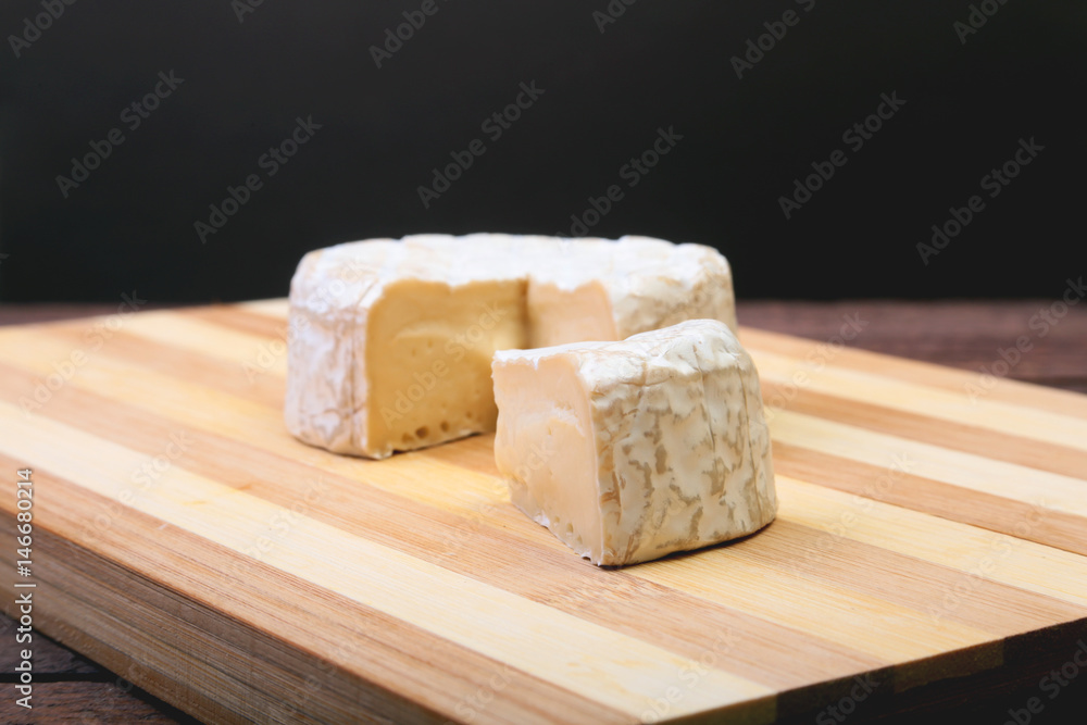 Cheese with white mold. Camembert or brie type on wood table. Healthy breakfast.