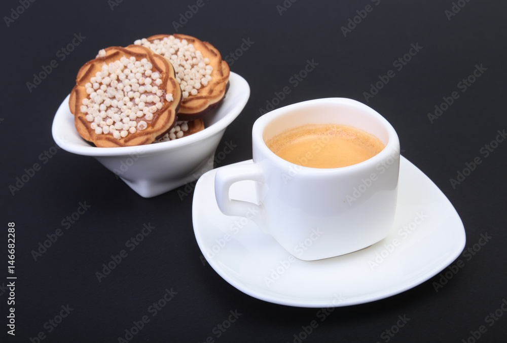 Classic espresso in white cup with homemade cake on black background. Selective focus. Classic espresso in white cup with homemade cake on black background. Selective focus.