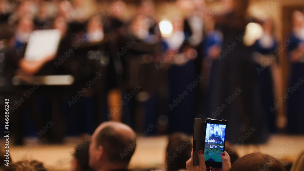Obraz premium Spectators at concert - people shooting performance on smartphone, music opera
