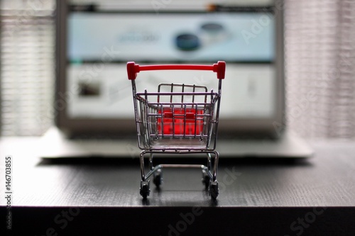 Red Shopping Cart in front of Notebook