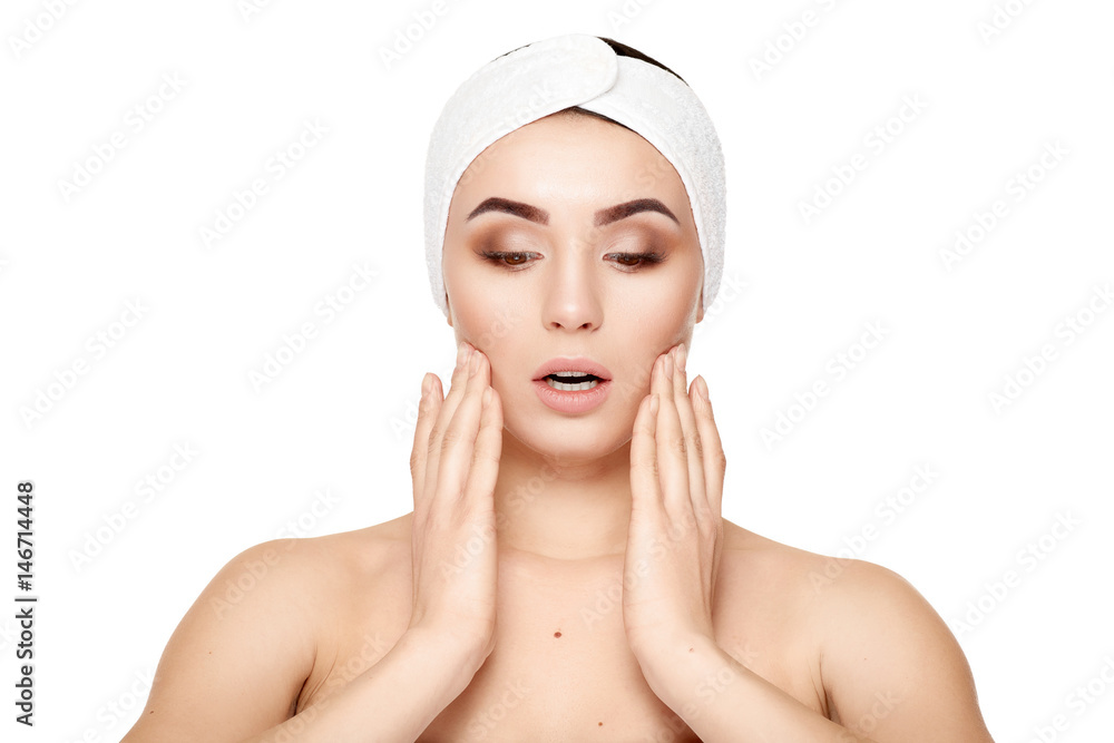 Beautiful young woman touching her face on a white background Beautiful young woman touching her face on a white background