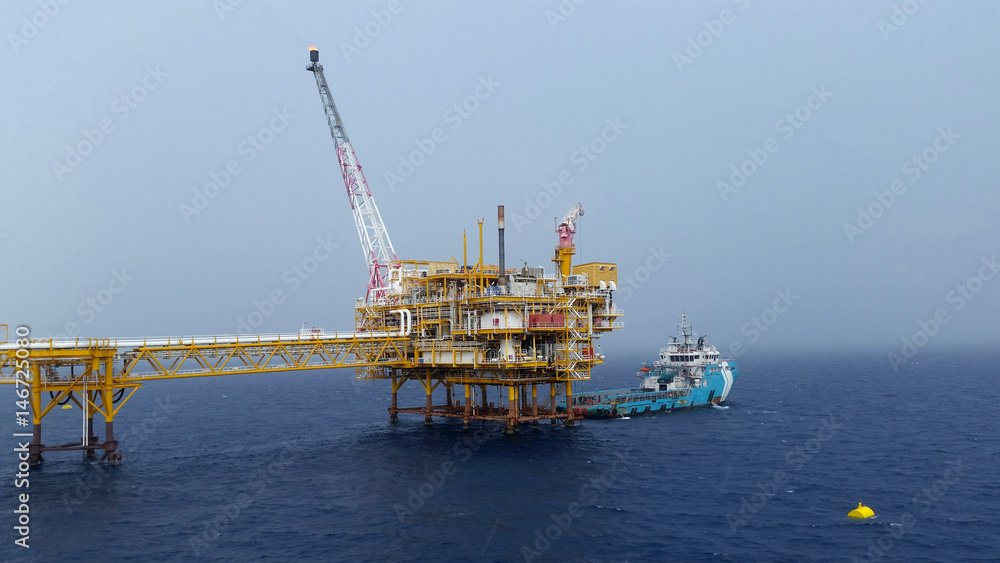 Fototapeta premium Supply boat transfer cargo to oil and gas industry and moving cargo from the boat to the platform