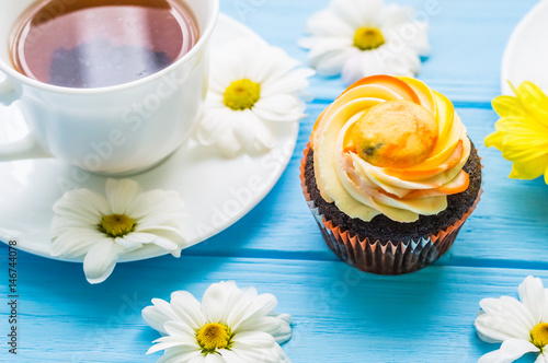 Still life with cup of tea and cake on the wooden background