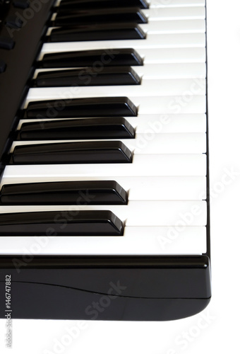 Piano keyboard with white and black keys on white background side view vertical  photo close up