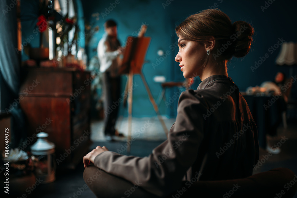 Obraz premium Female poseur, painter against easel on background
