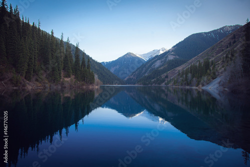 Majestic blue mountain lake with green trees