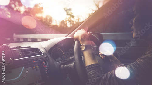 Fotografie Woman driving a map to direct sunlight in the evening