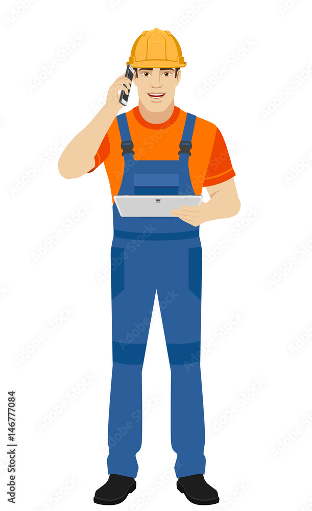 Builder holding digital tablet and talking on the mobile phone