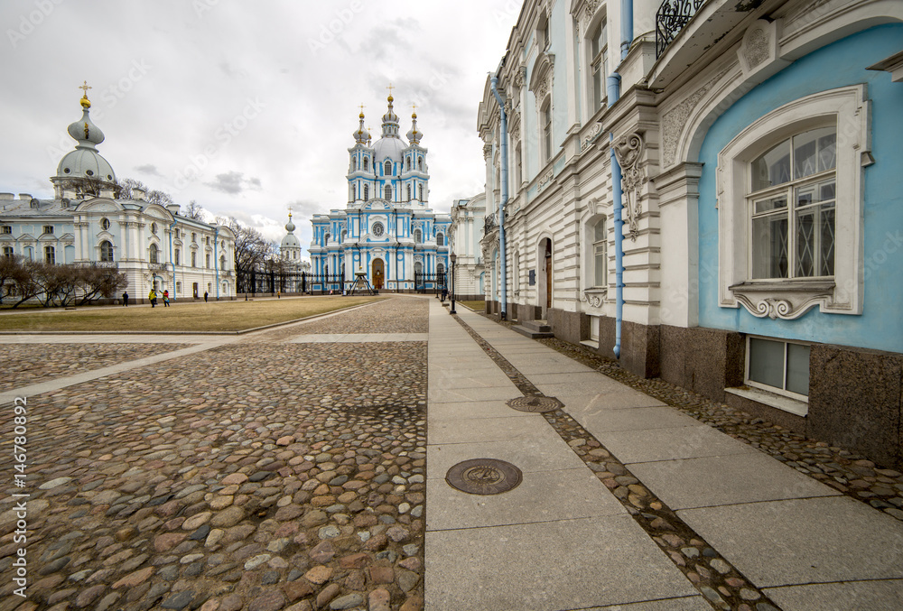 Russia, St. Petersburg. Smolny Cathedral (Church of the Resurrection). Paving stones. Gloomy sky. Wide angle lens.