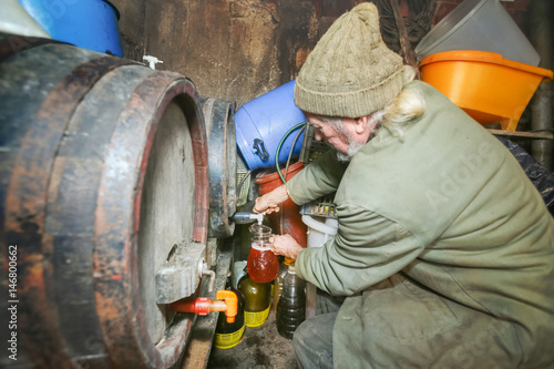 Man pouring wine from barrel