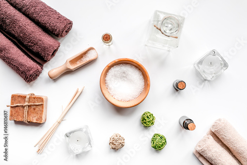 spa cosmetics with soap, salt, oil on white background top view