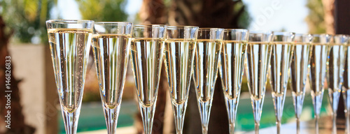 Many glasses of champagne or prosecco near resort pool in a luxury hotel. Pool party.