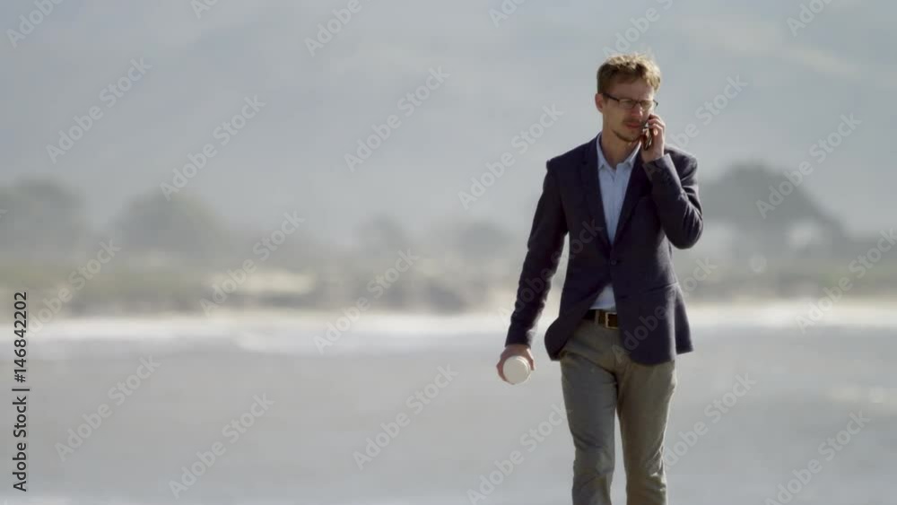 Young man walking along the Pacific ocean coast Young man walking along the Pacific ocean coast