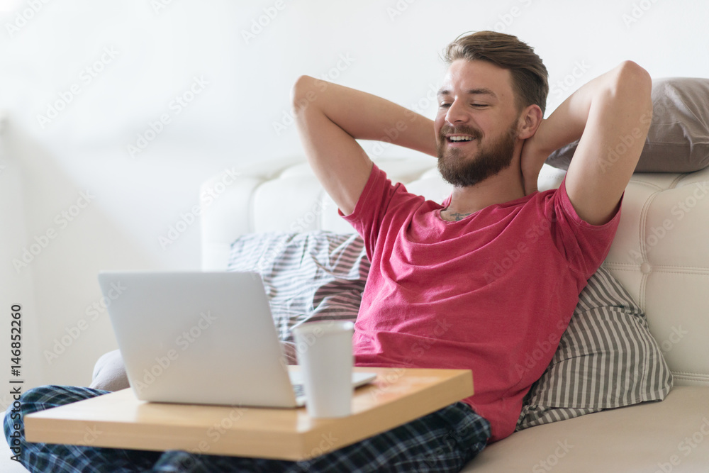 Young Caucasian man using his lap top at his home. Young Caucasian man using his lap top at his home.