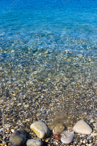 sea pebble beach with multicoloured stones  waves with foam