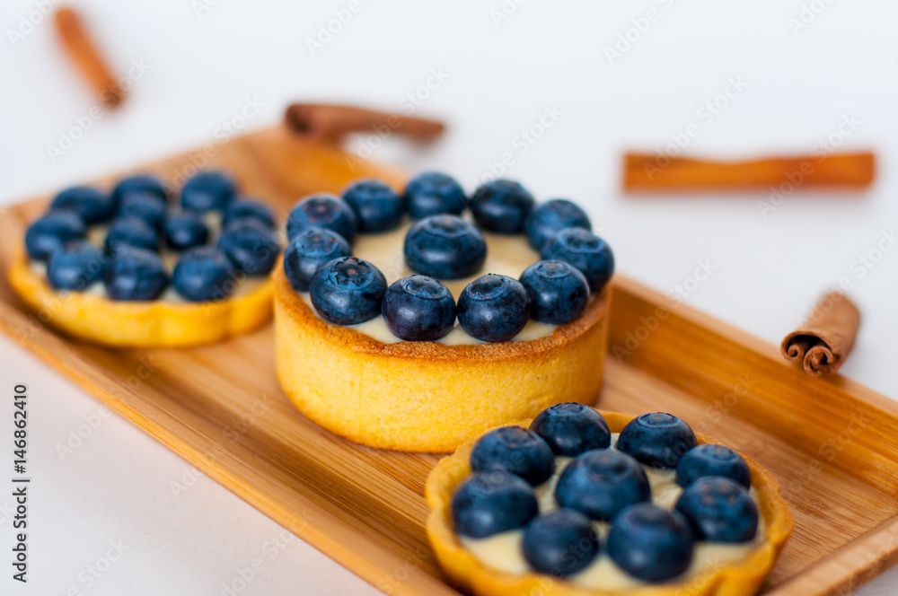 Tarts with blueberries on the rectangular wooden plate Tarts with blueberries on the rectangular wooden plate