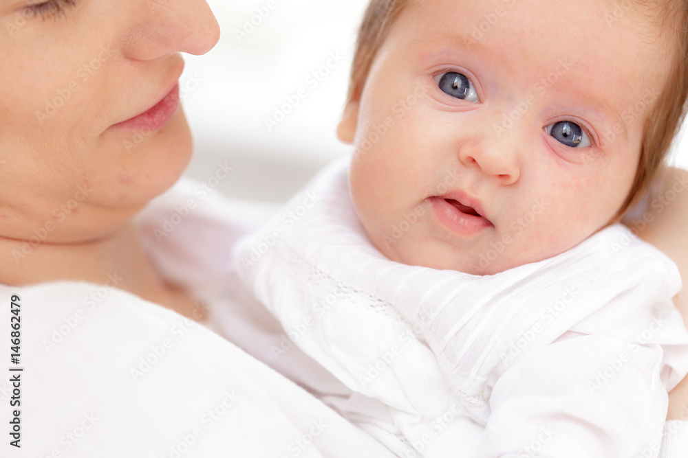 Young mother and newborn baby in white bedroom Young mother and newborn baby in white bedroom