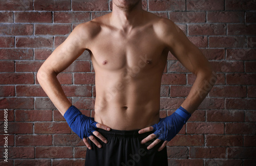 Young sporty man on brick wall background